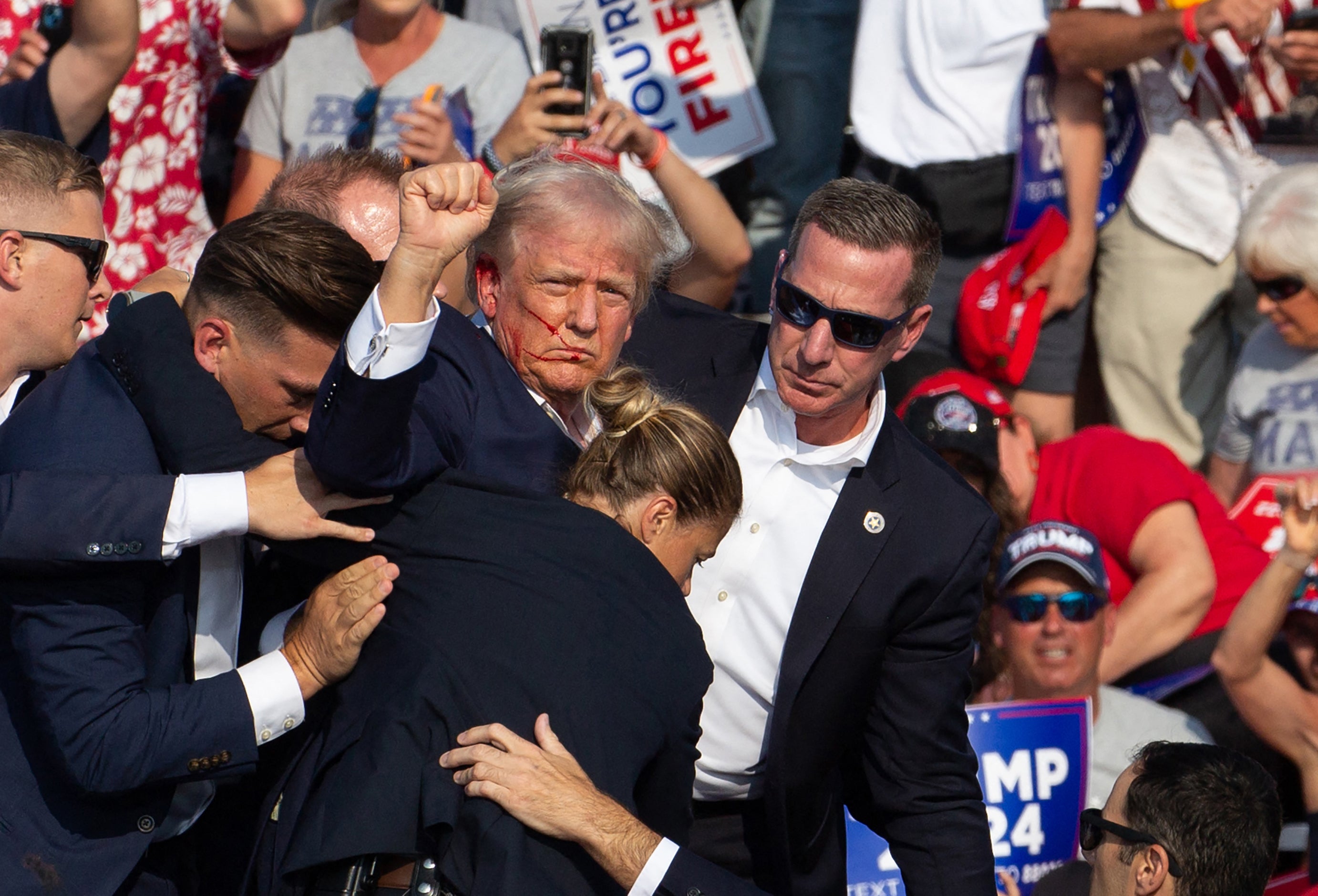 Agen Dinas Rahasia membawa Donald Trump ke panggung setelah seorang pria bersenjata melepaskan tembakan pada kampanye di Pennsylvania pada 13 Juli.