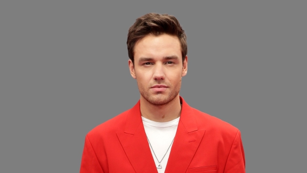 Liam Payne mengenakan blazer merah di foto potret.