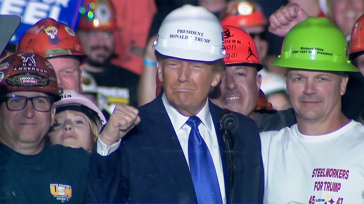 Donald Trump memakai topi keras