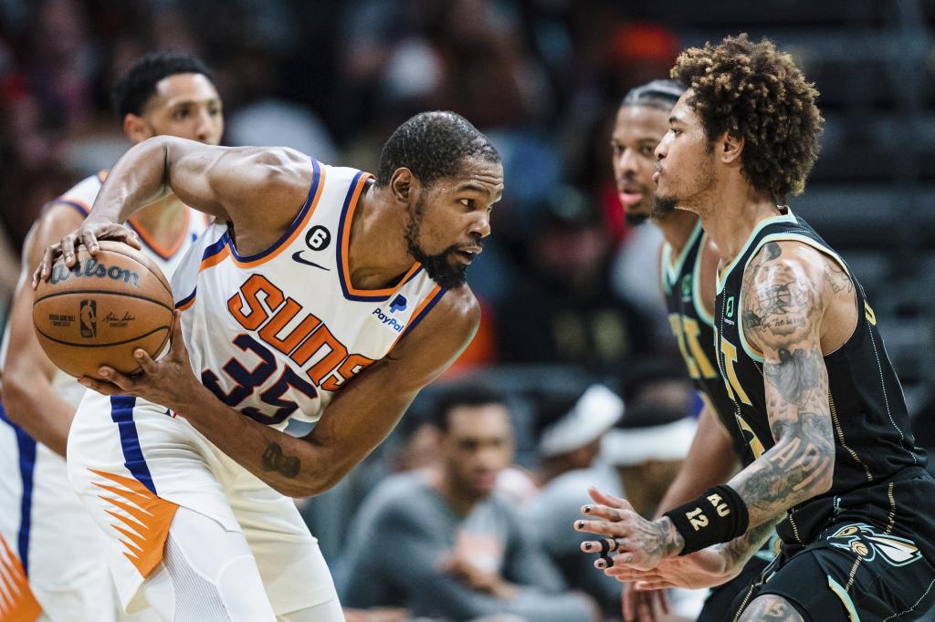 Kevin Durant, dibela oleh Kelly Oubre Jr. dalam pertandingan antara Suns dan Hornets.