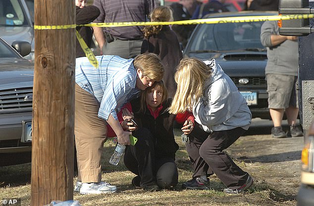 Orang-orang terhibur di dekat Sekolah Dasar Sandy Hook di Newtown pada 14 Desember 2012.