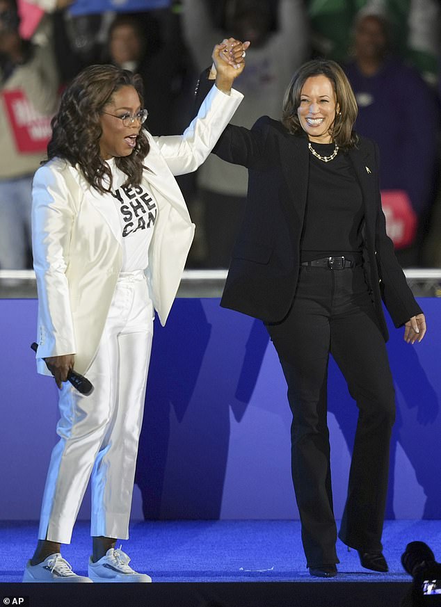 Oprah Winfrey berpegangan tangan setelah memperkenalkan calon presiden dari Partai Demokrat, Wakil Presiden Kamala Harris, untuk berbicara pada rapat umum kampanye di luar museum Philadelphia Senin malam lalu.