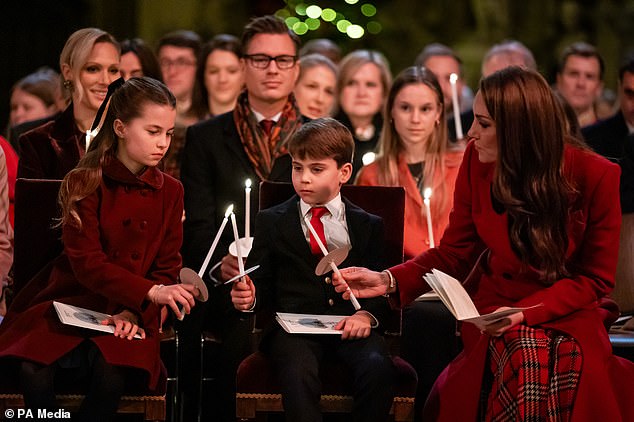 Putri Charlotte, Pangeran Louis dan Putri Wales memegang lilin saat mereka duduk di bangku gereja di Westminster Abbey selama kebaktian