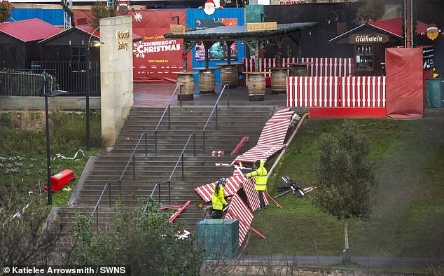 Para pekerja berupaya memperbaiki pagar yang rusak akibat angin kencang di pasar Natal Edinburgh