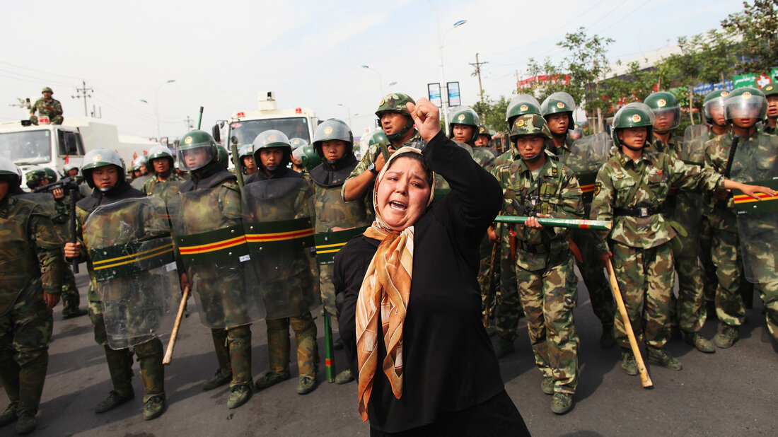 URUMKI, CHINA - 07 JULI: Seorang wanita Uyghur memprotes polisi di jalan 7 Juli 2009 di Urumqi, Daerah Otonomi Uyghur Xinjiang, Tiongkok. (Foto oleh Guang Niu/Getty Images)