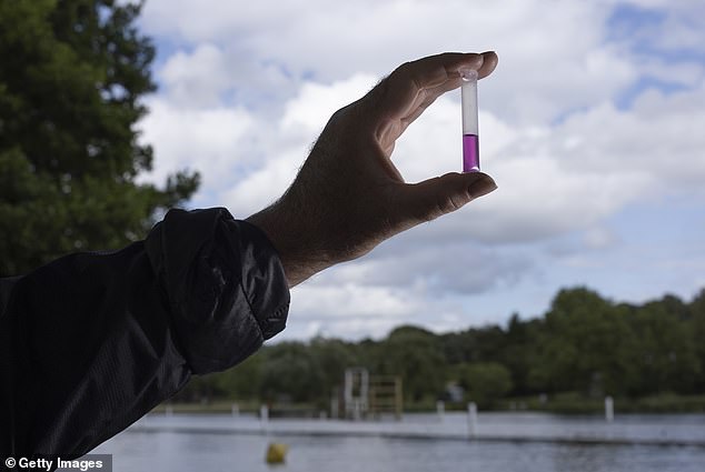 David Wallace, relawan sains warga dari 'Henley River Action Group', memegang sampler untuk menguji kadar nitrogen air sungai selama uji kualitas air di Sungai Thames di Henley-on-Thames pada 12 Juli 2023.