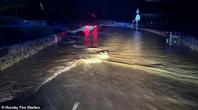 Gambar: Sebuah mobil terjebak dalam banjir di Gressingham, Lancashire