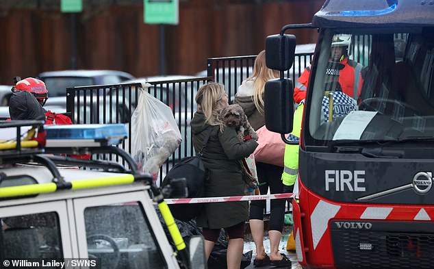 Warga mengevakuasi gedung Meadow Mill di Water Street, Stockport, setelah terendam banjir hari ini