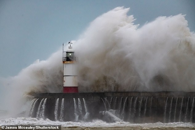 Ombak menghantam mercusuar di Pelabuhan Newhaven di Sussex Timur sore ini
