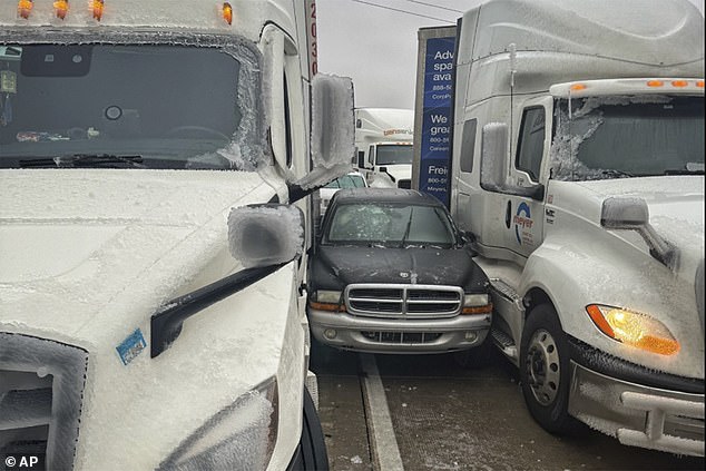 Gambar: Sebuah mobil terbelah di antara dua truk dalam kondisi bersalju di Kansas pada hari Sabtu