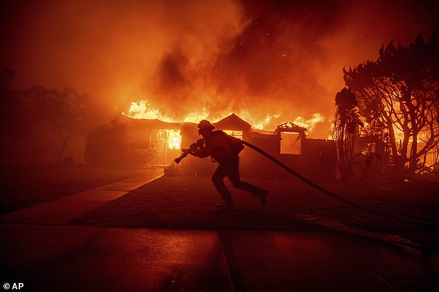 Petugas pemadam kebakaran memadamkan Kebakaran Palisades saat membakar sebuah bangunan di lingkungan Pacific Palisades di Los Angeles pada hari Selasa