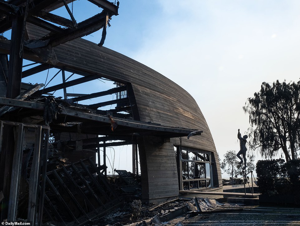 Sebuah patung menarik tetap utuh di luar sisa-sisa rumah petak Pacific Palisades yang berharga