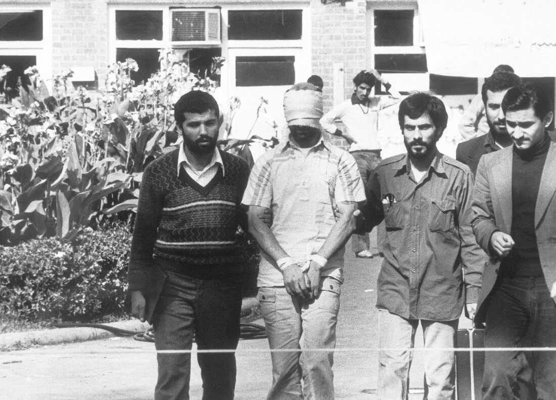 Dalam file foto bertanggal 8 November 1979 ini, mahasiswa Iran memamerkan salah satu sandera di Kedutaan Besar AS di Teheran, Iran.