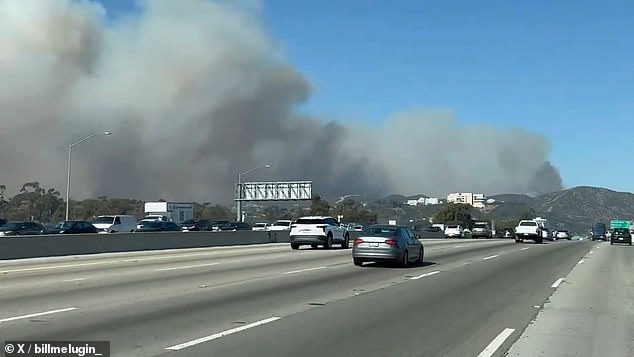 Rekaman dari hari sebelumnya menunjukkan setidaknya satu rumah terbakar di sebuah lembah dekat Sepulveda Pass di Highway 405 dan mengepulkan asap tebal.