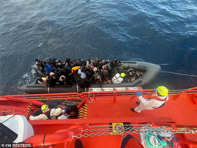 Dalam foto selebaran yang diambil pada 8 Januari 2025 ini, penjaga pantai Spanyol berjas putih sedang melakukan operasi penyelamatan saat mereka menarik perahu karet yang membawa migran, termasuk bayi yang baru lahir, di sebuah pulau dekat Pulau Canary di Lanzarote, Spanyol.