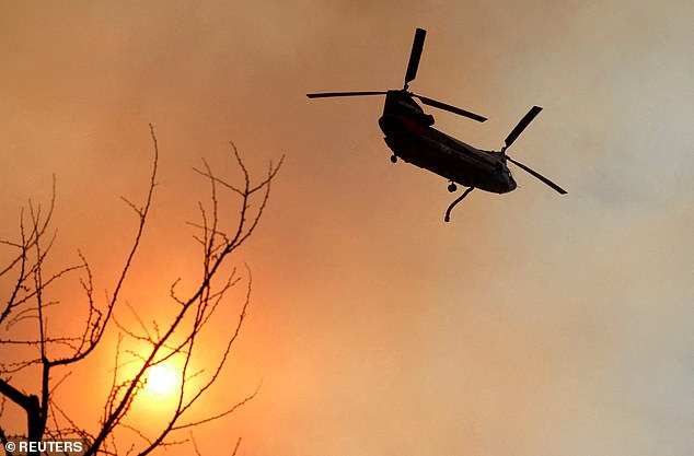 Sebuah helikopter terbang di atas Palisades Fire, salah satu dari beberapa kebakaran serentak yang terjadi di Los Angeles County.