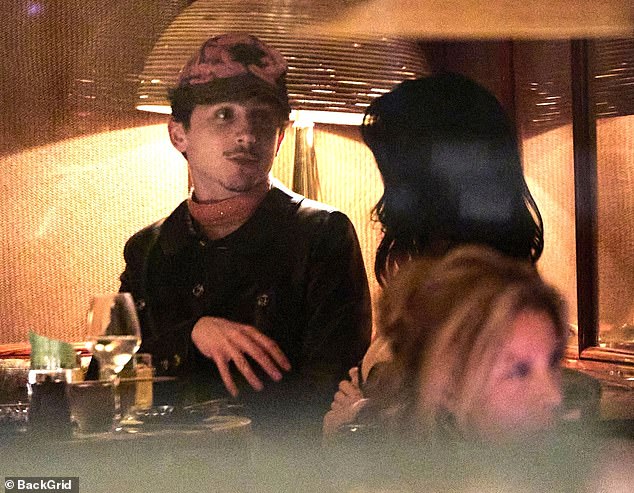 Duduk bersama pacarnya, Chalamet mengenakan topi berhias dan jaket kulit tanpa kerah yang sama seperti yang dia modelkan beberapa jam sebelumnya di pemutaran perdana film barunya di Paris.
