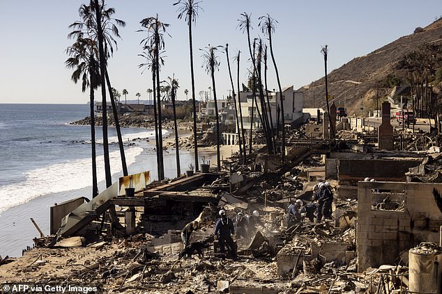 Petugas pemadam kebakaran dari Satuan Tugas Pencarian dan Penyelamatan Perkotaan California menyisir puing-puing rumah tepi pantai tempat para korban kebakaran Los Angeles dilaporkan dimakamkan di Malibu.