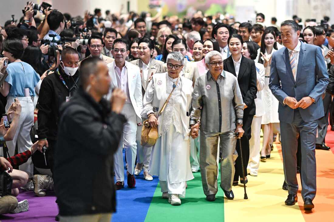 Mantan perdana menteri Thailand Sretta Thawisin (kanan) tiba bersama pasangan sesama jenis pada upacara pencatatan pernikahan di Paragon Shopping Mall di Bangkok pada hari Kamis.