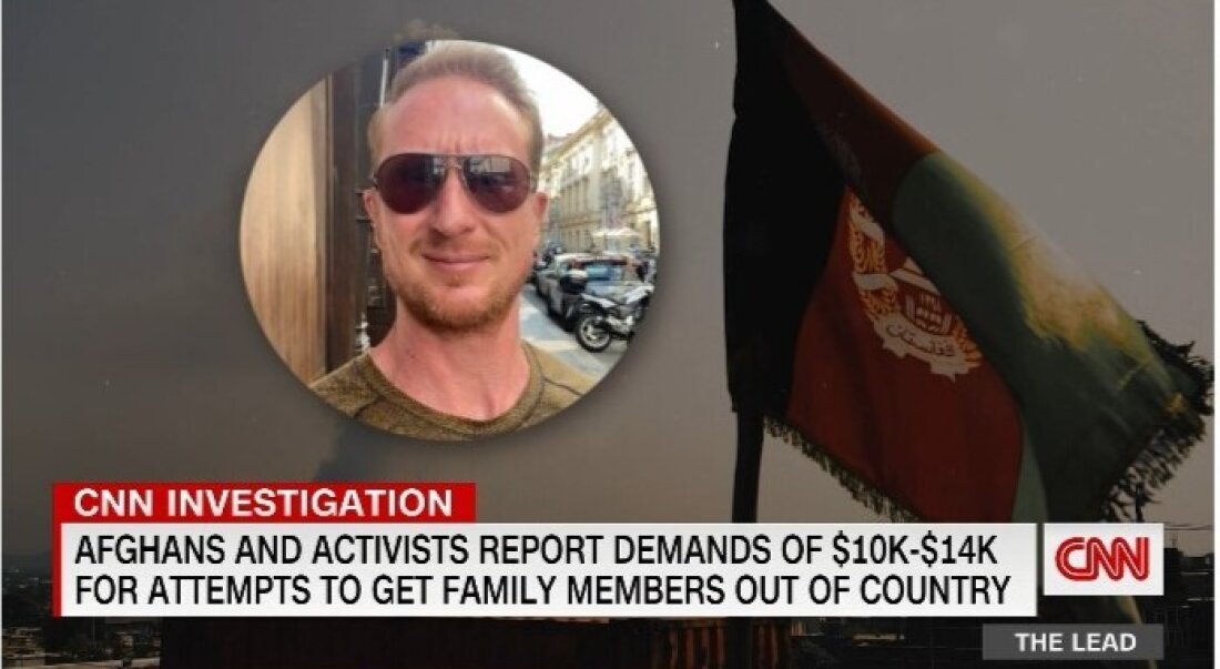 Tangkapan layar menunjukkan seorang pria mengenakan kacamata hitam di atas ticker berita yang menampilkan berita utama tentang investigasi CNN. 
