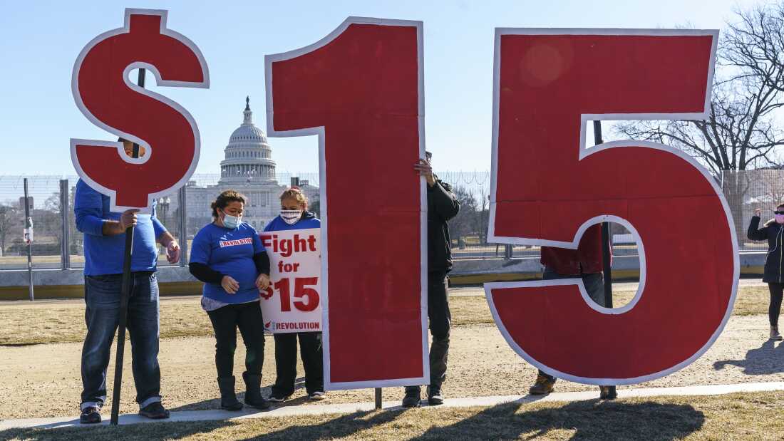 Para aktivis menyerukan upah minimum $15 di dekat Capitol di Washington pada tahun 2021. Dengan dimulainya tahun baru, upah minimum akan meningkat menjadi $15 per jam di Delaware, Illinois dan Rhode Island, begitu pula di 10 negara bagian dan Washington, DC. Upah minimum adalah $15 atau lebih.