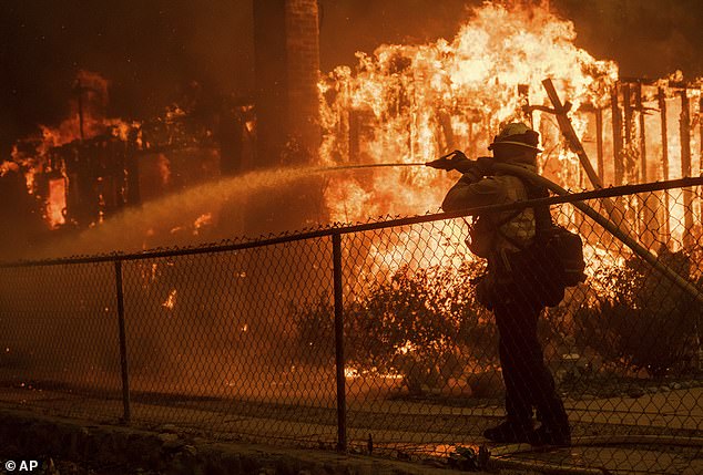 Petugas pemadam kebakaran menyemprotkan air ke rumah yang terbakar dalam Kebakaran Eaton di Altadena, California, Rabu, 8 Januari.