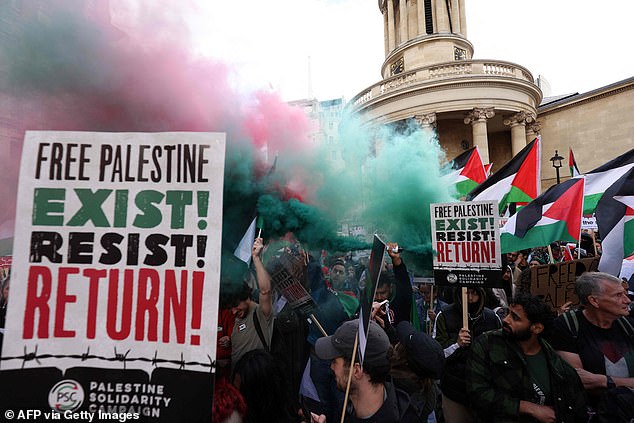 Para pengunjuk rasa meletakkan kaleng asap di dekat rumah siaran BBC saat mereka mengumpulkan untuk mendukung Palestina pada 14 Oktober