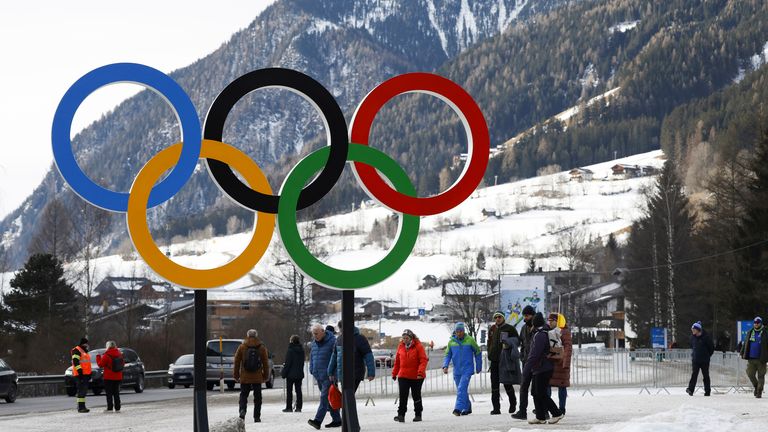 Orang -orang mendekati cincin Olimpiade dekat desa Anteselva di mana biathlon akan berlangsung selama Olimpiade Musim Dingin Milan 2026 di Italia utara, Sabtu, 25 Januari 2025. (Foto AP/Alessandro Trivati)